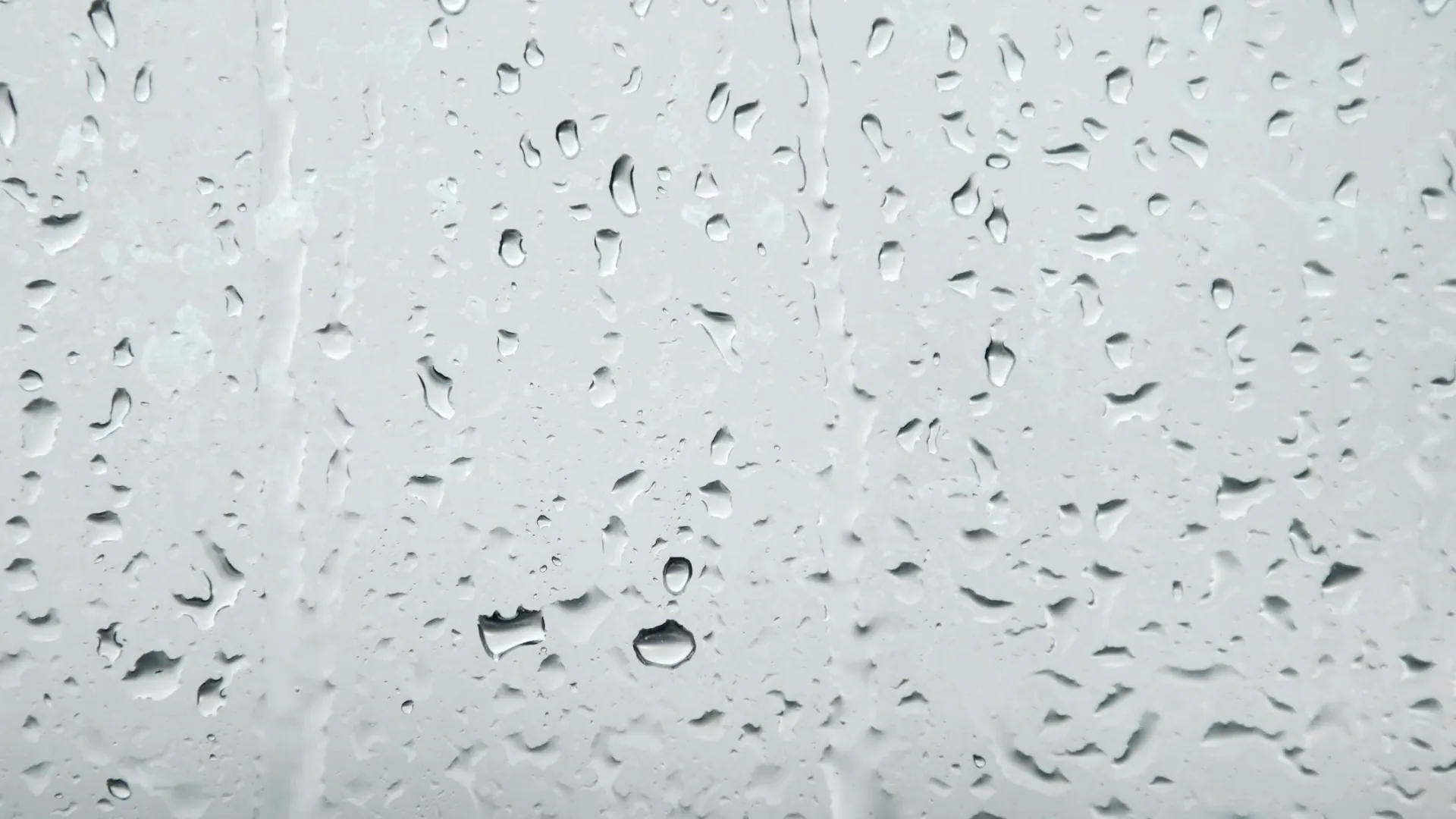 Gotas de agua recorriendo un cristal, plano macro
